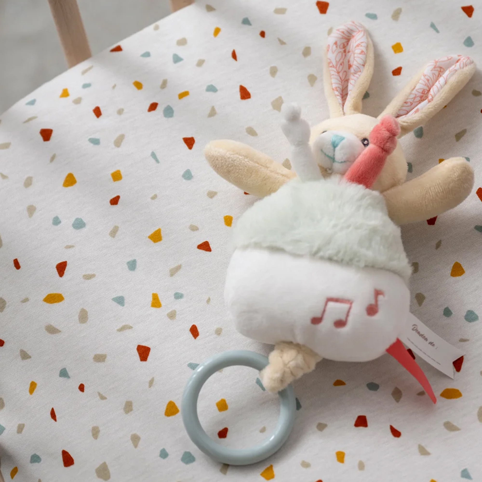 photo de drap housse bébé imprimé terrazzo avec peluche lapin bébé